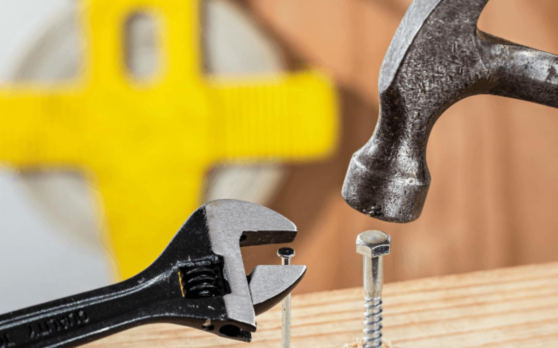 Metaphor image for complexity / uncertainty with wrench used on nail and hammer pounding in a bolt